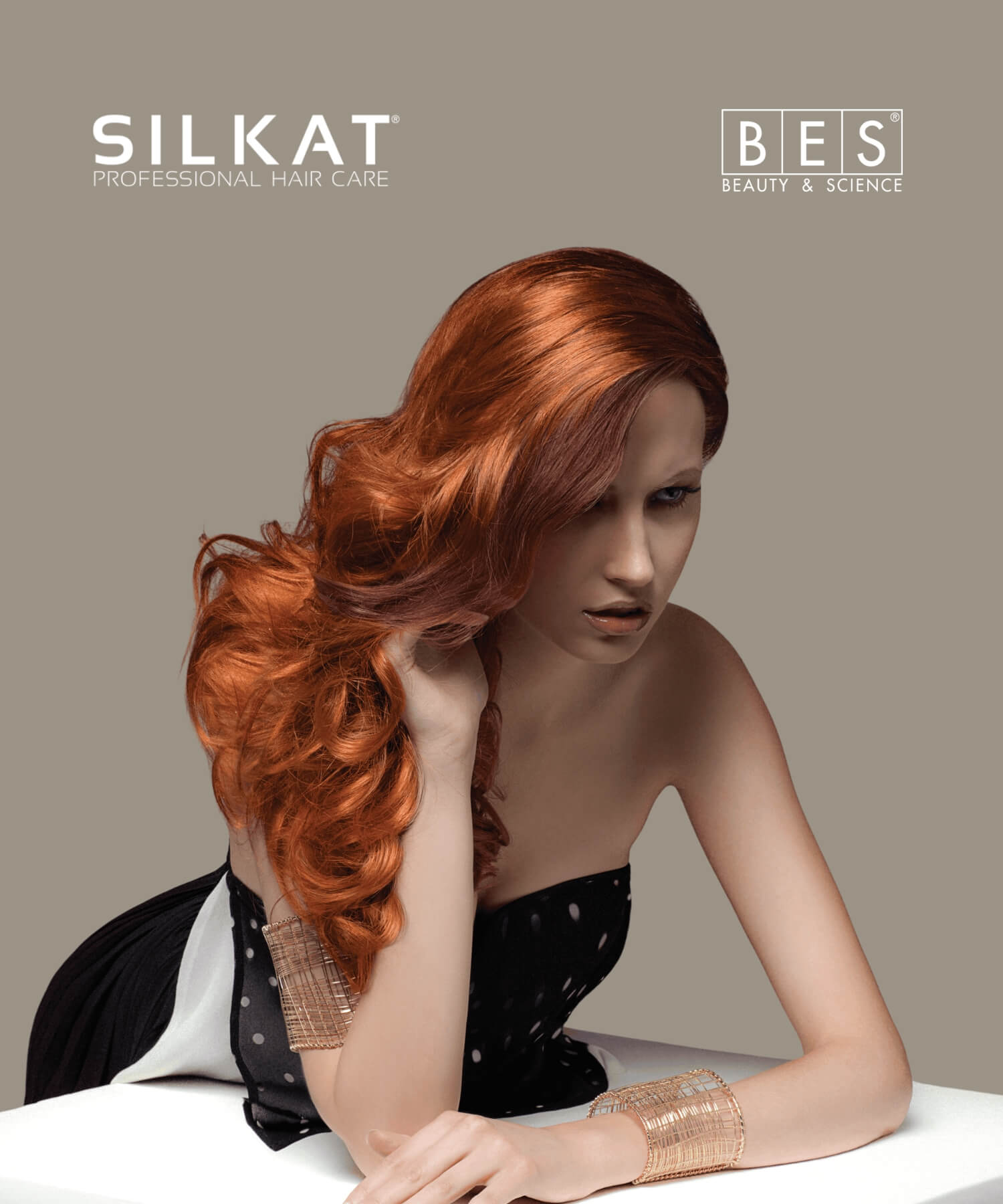 A woman with long, wavy red hair poses in a strapless black and white dress against a plain gray background, with "SILKAT Professional Hair Care" and "BES Beauty & Science" logos above.